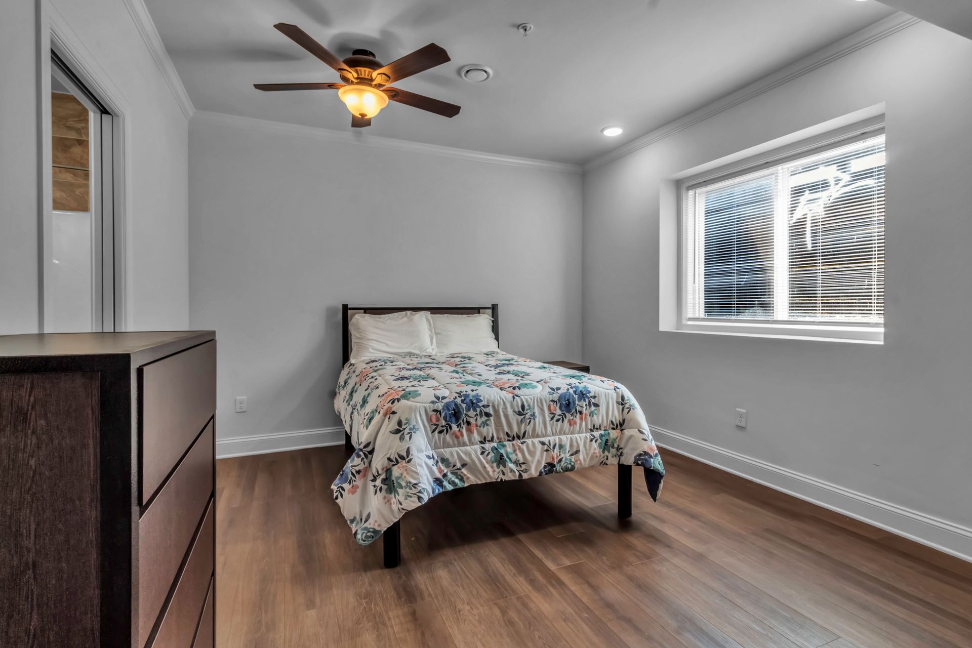 A bedroom with a bed and a ceiling fan