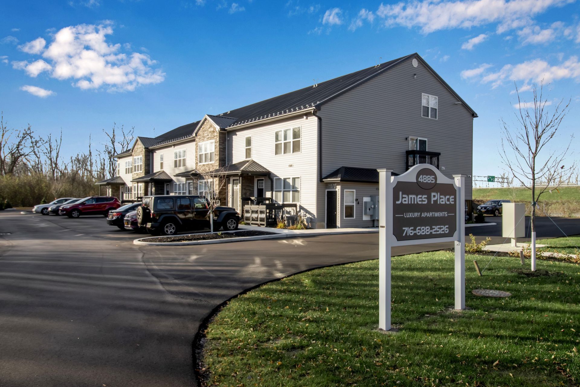 A building with a sign in front of it and cars parked in front of it.