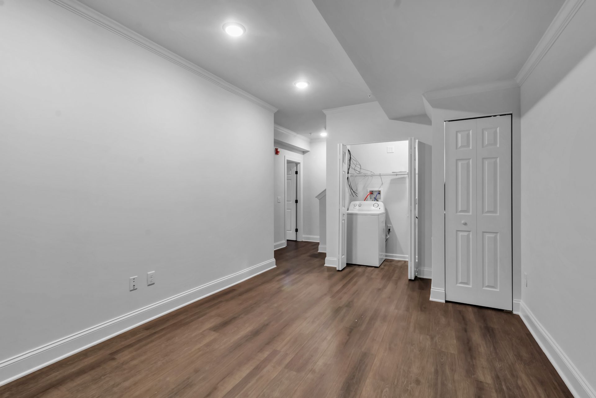 An empty basement with a washer and dryer in it.
