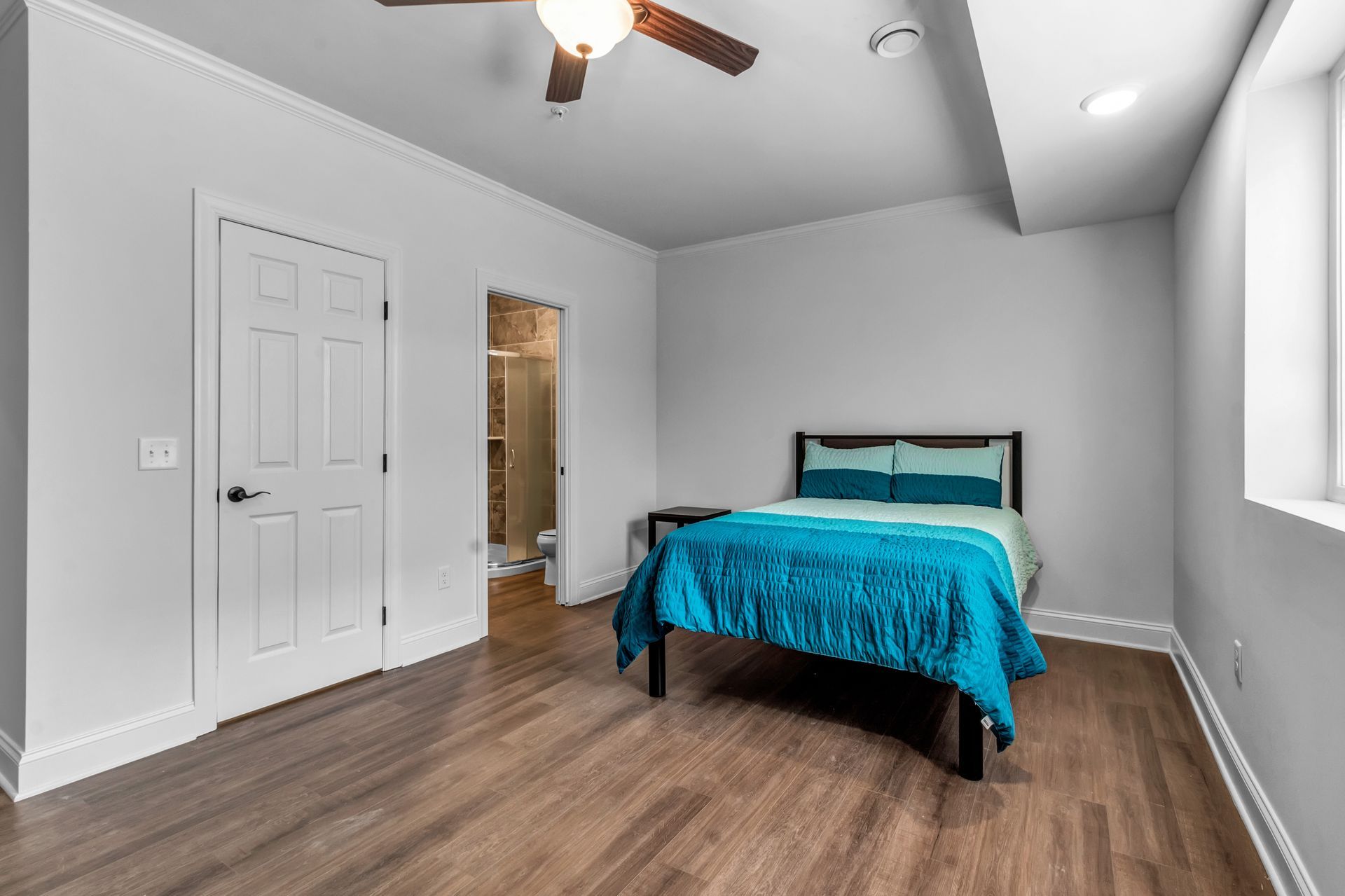 A bedroom with a bed and a ceiling fan.