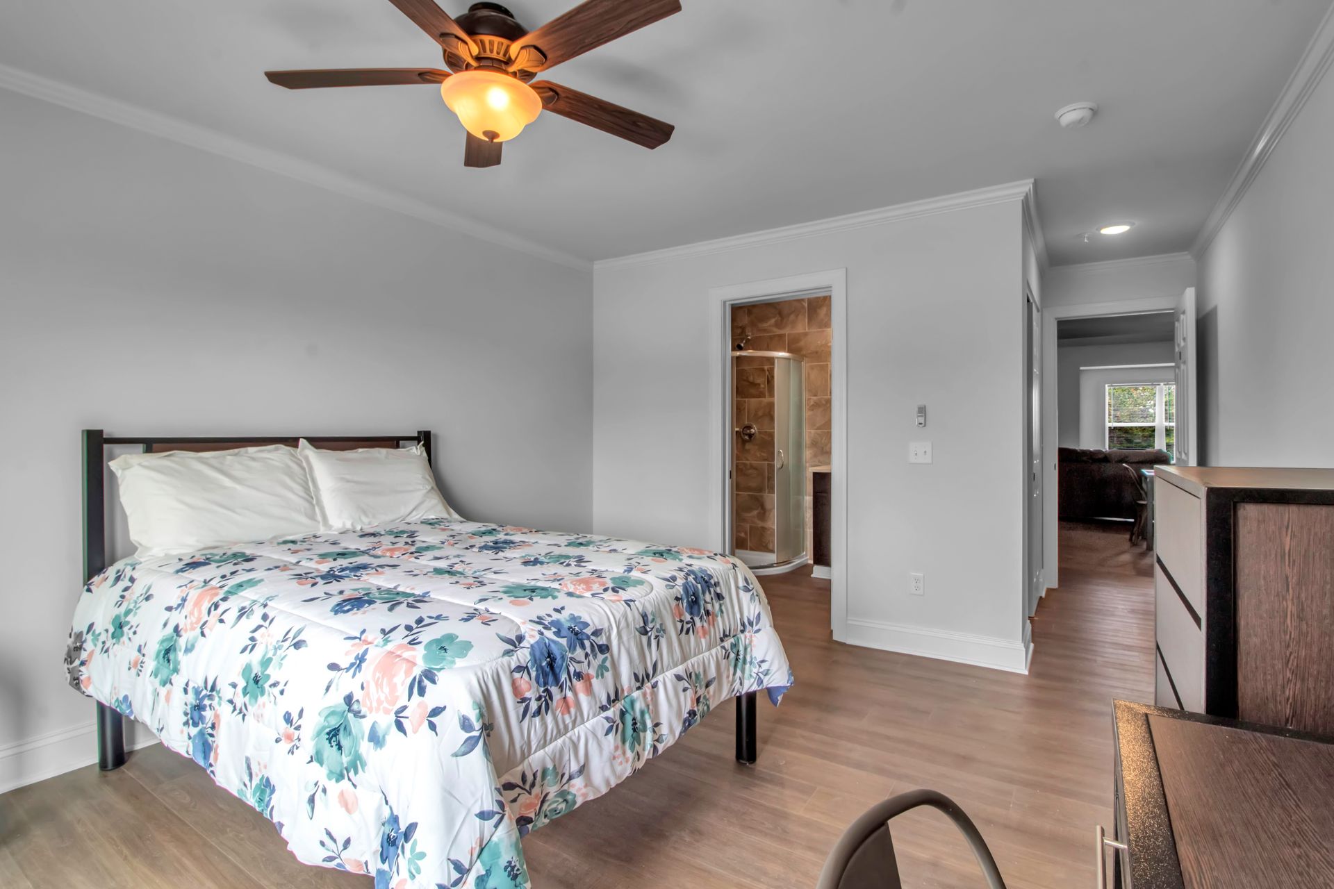 A bedroom with a bed and a ceiling fan.