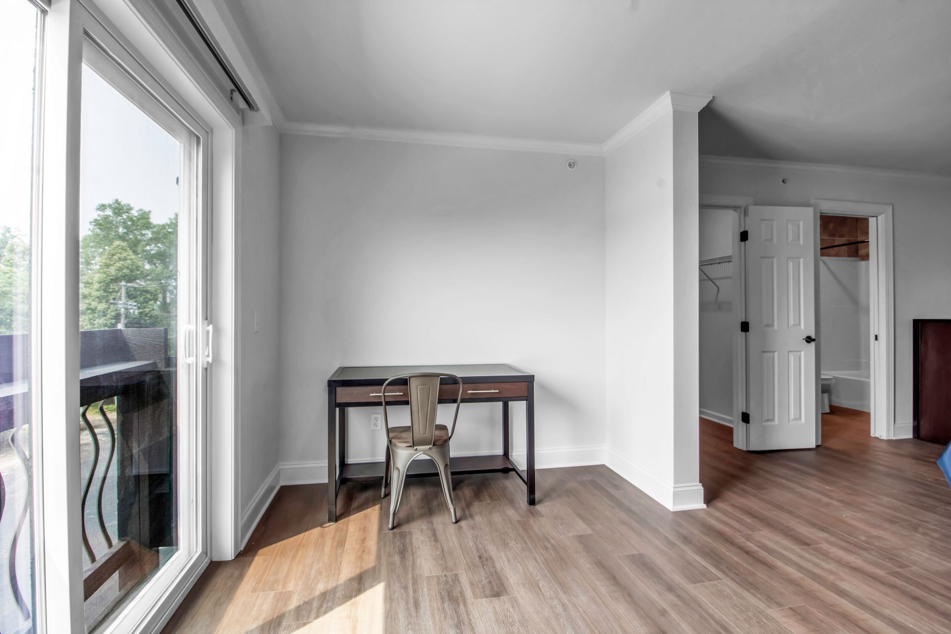 There is a desk and chair in the middle of the room.