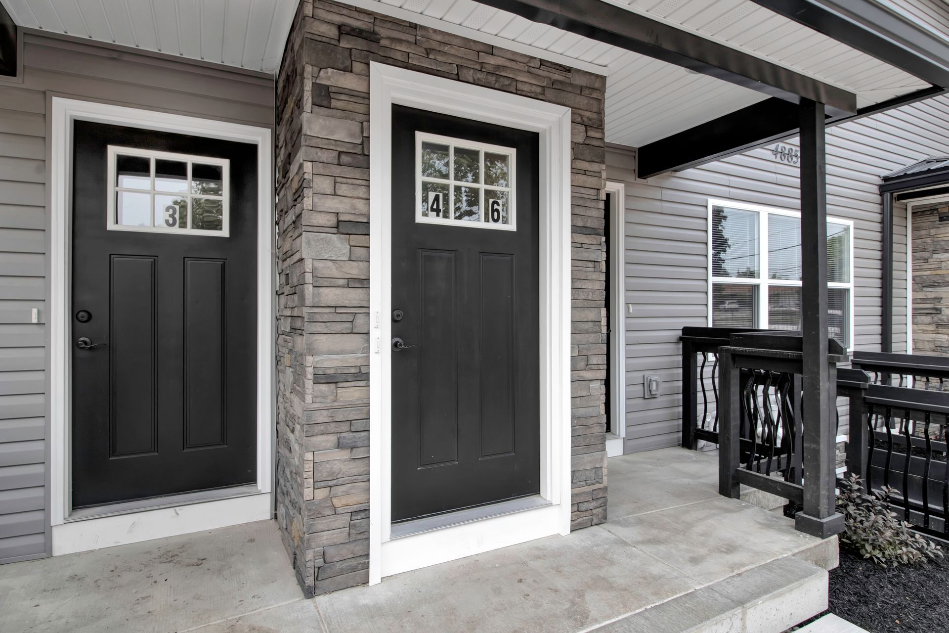 There are two black doors on the front of a house.
