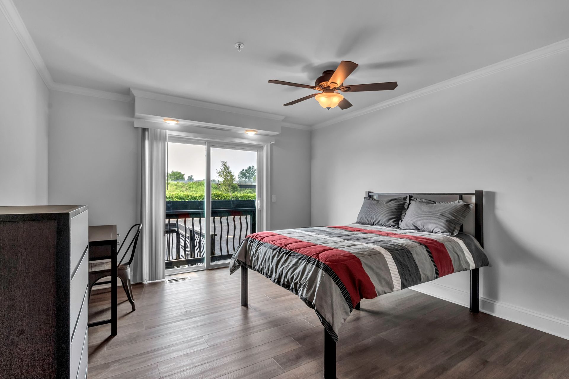 A bedroom with a bed and a ceiling fan.