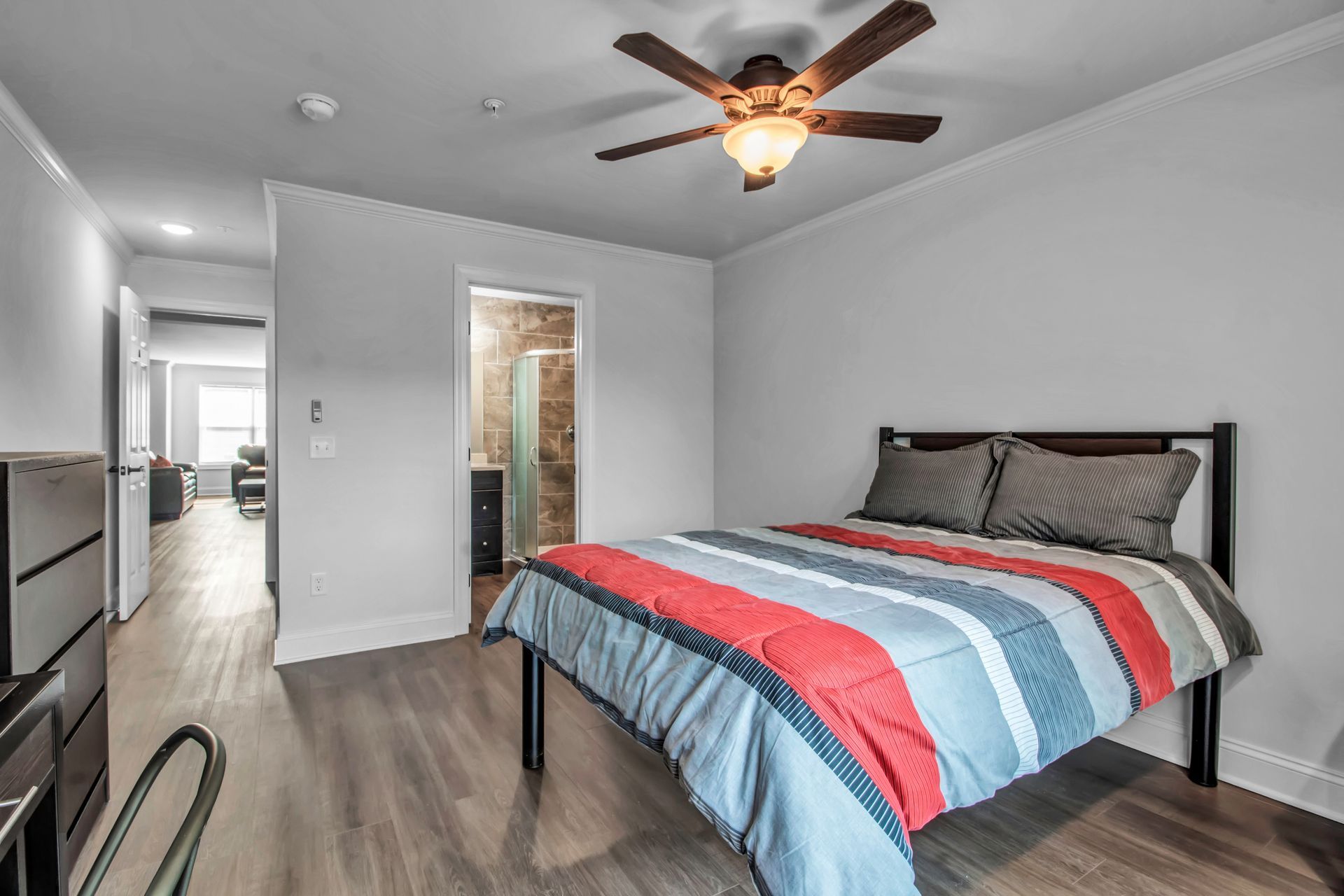 A bedroom with a bed and a ceiling fan.