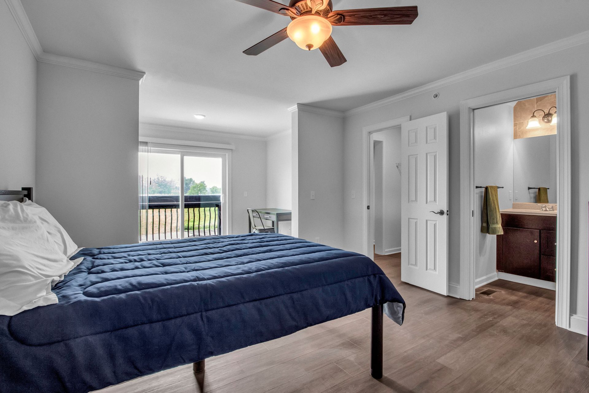 A bedroom with a bed and a ceiling fan.