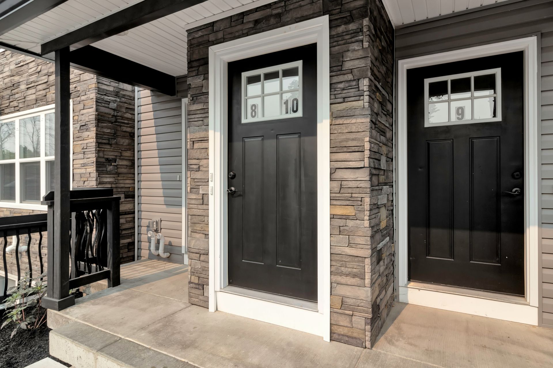 There are two black doors on the front of a house.