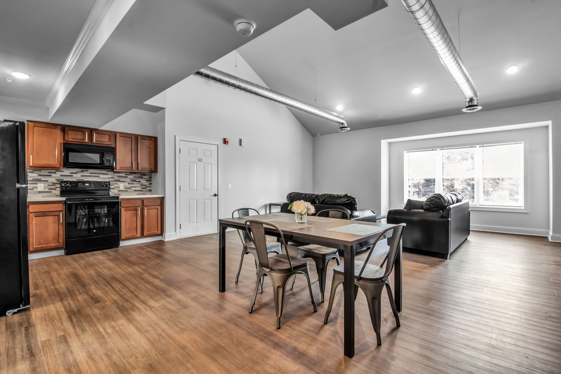 There is a dining table and chairs in the middle of the room.