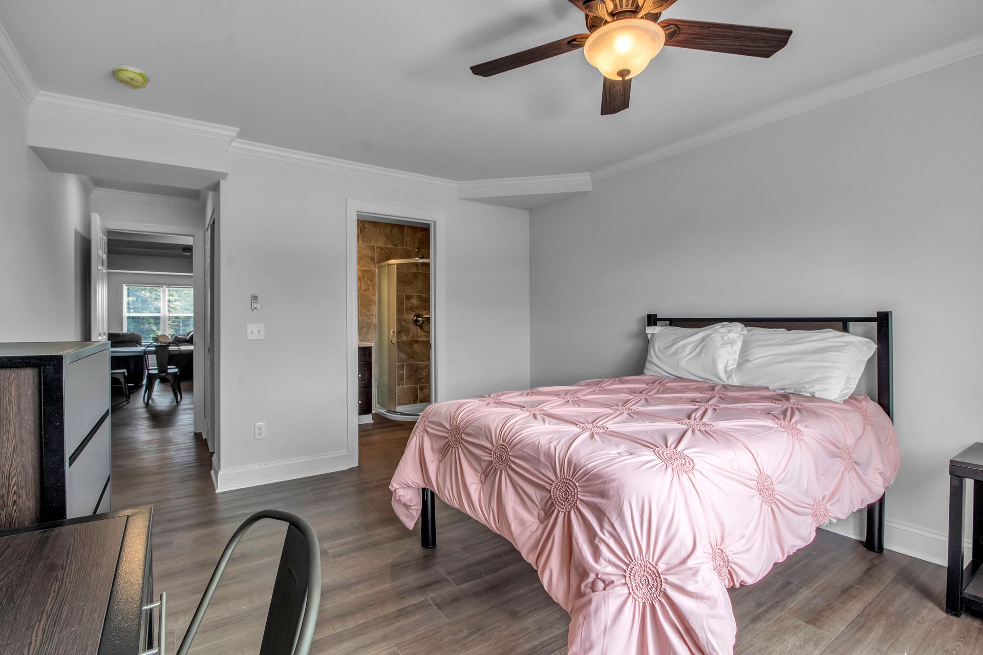 A bedroom with a bed and a ceiling fan.