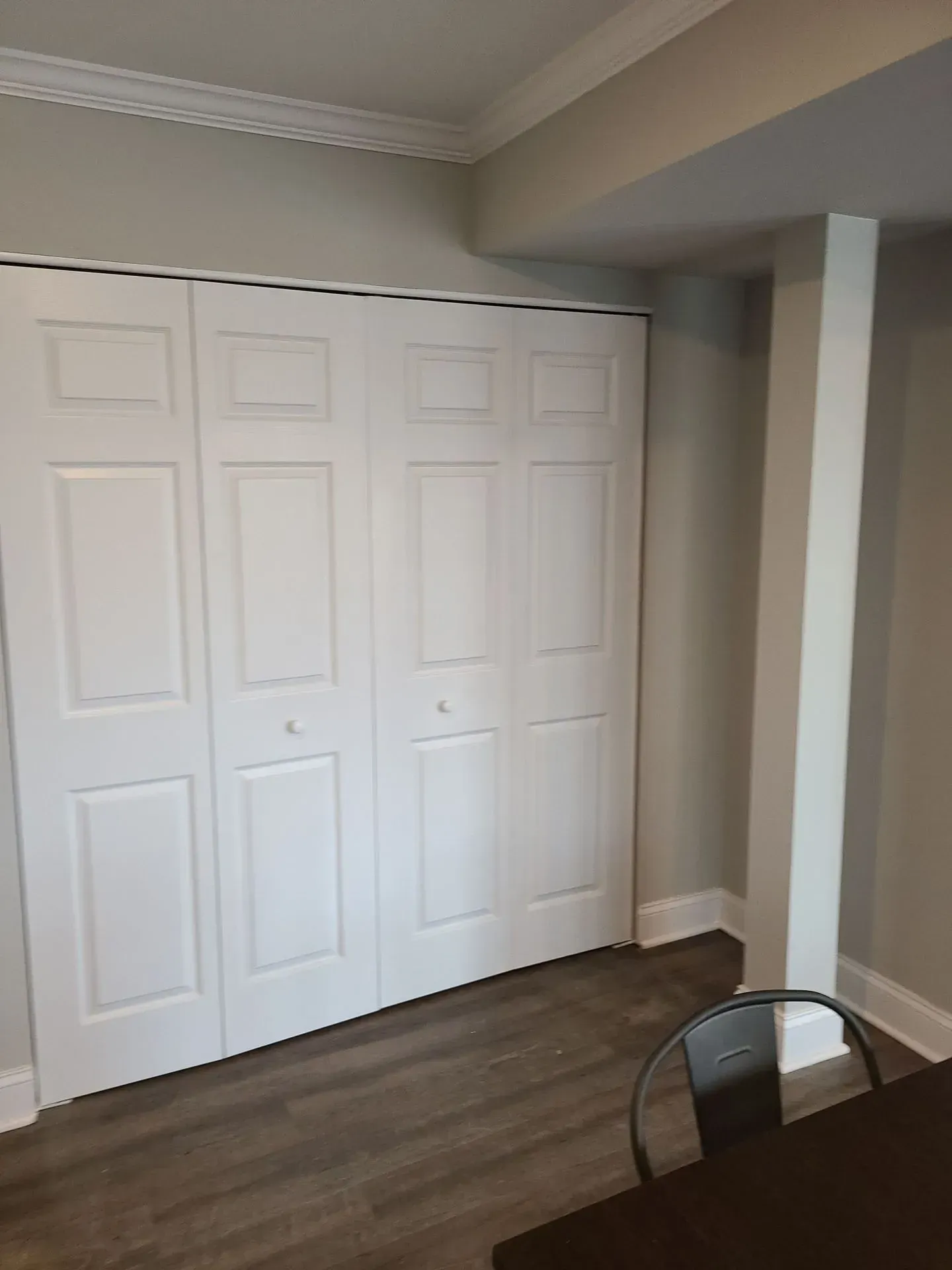 A room with a table and chairs and a closet with white doors.