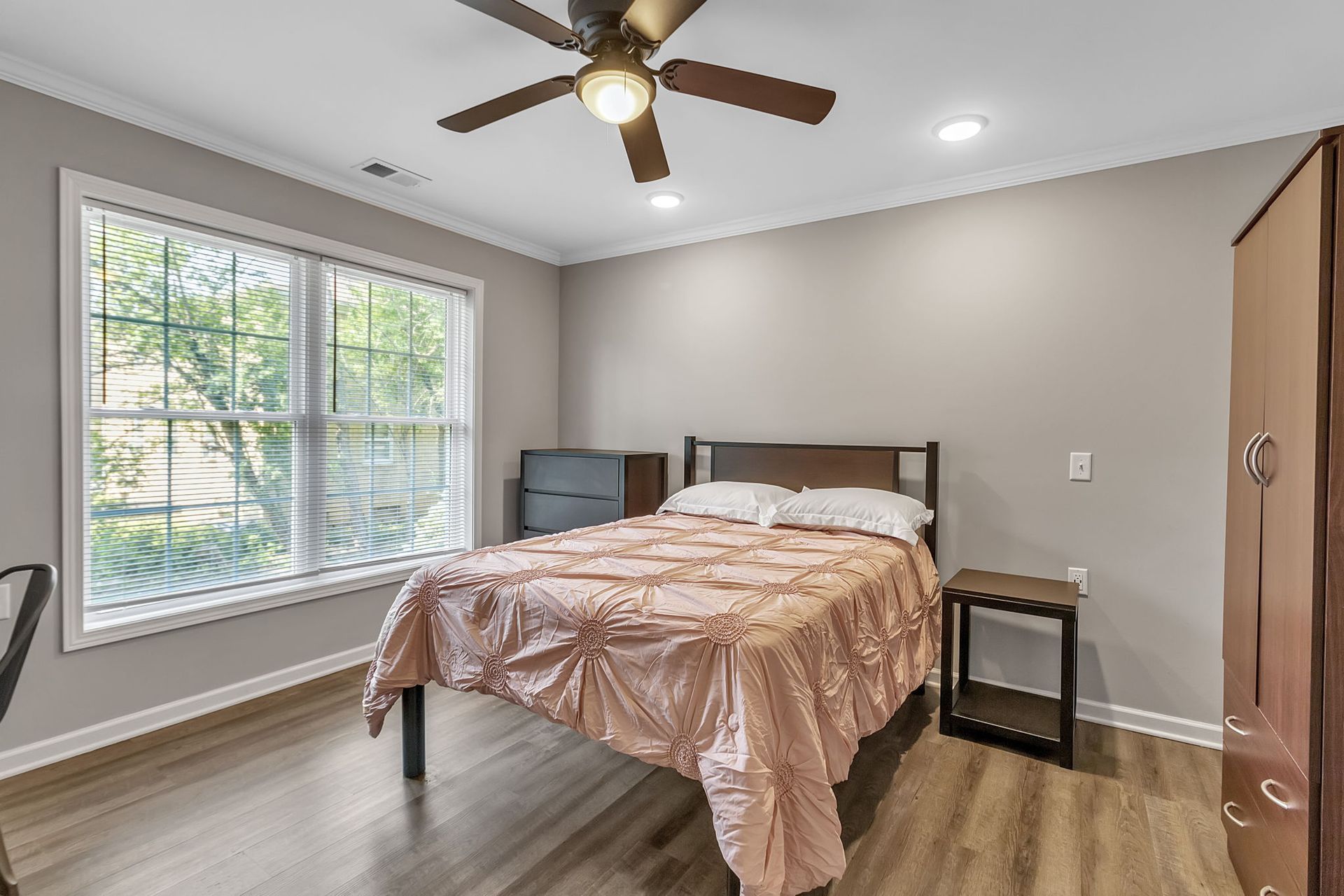 A bedroom with a bed and a ceiling fan.