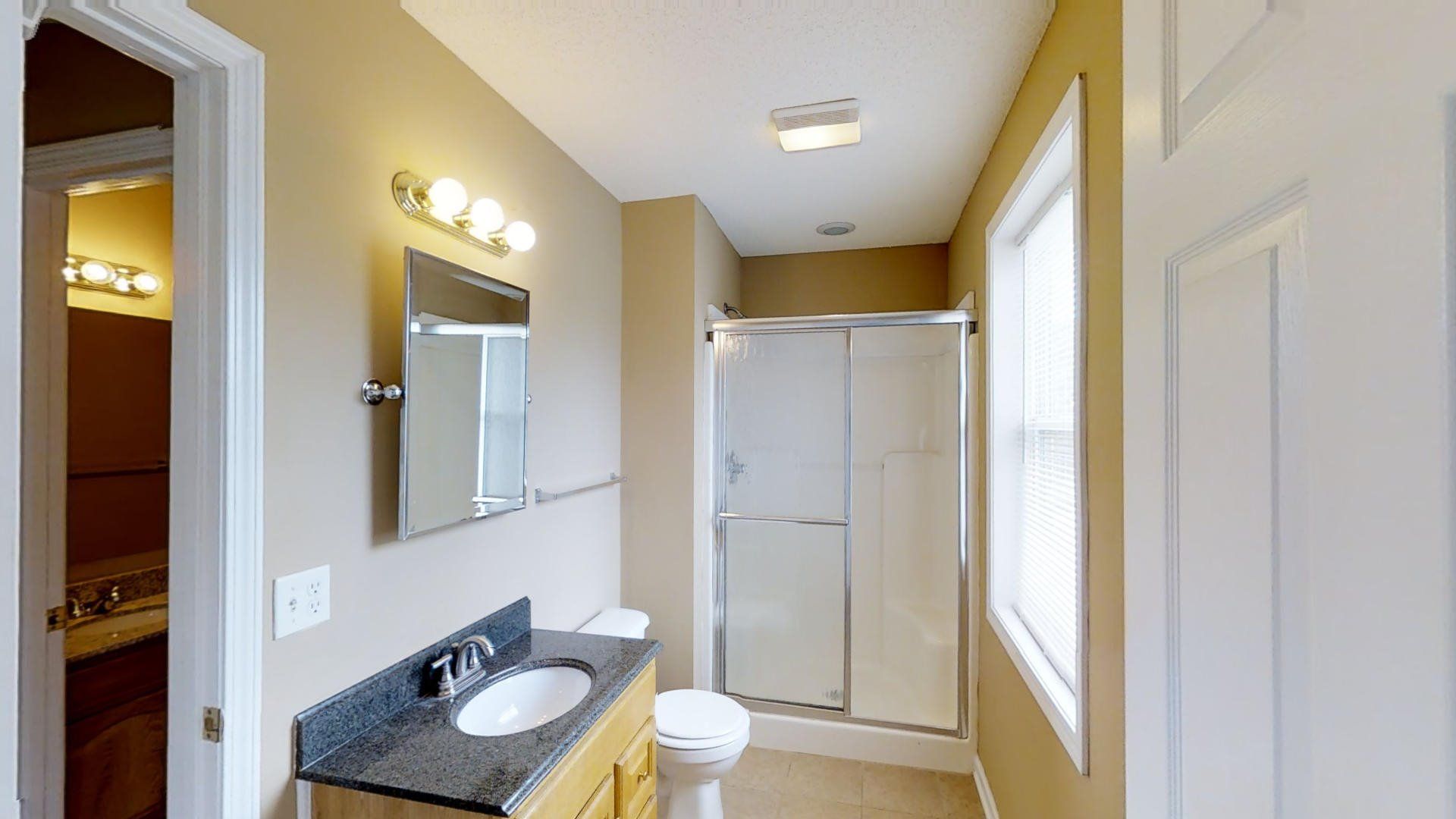 A bathroom with a sink , toilet and shower.