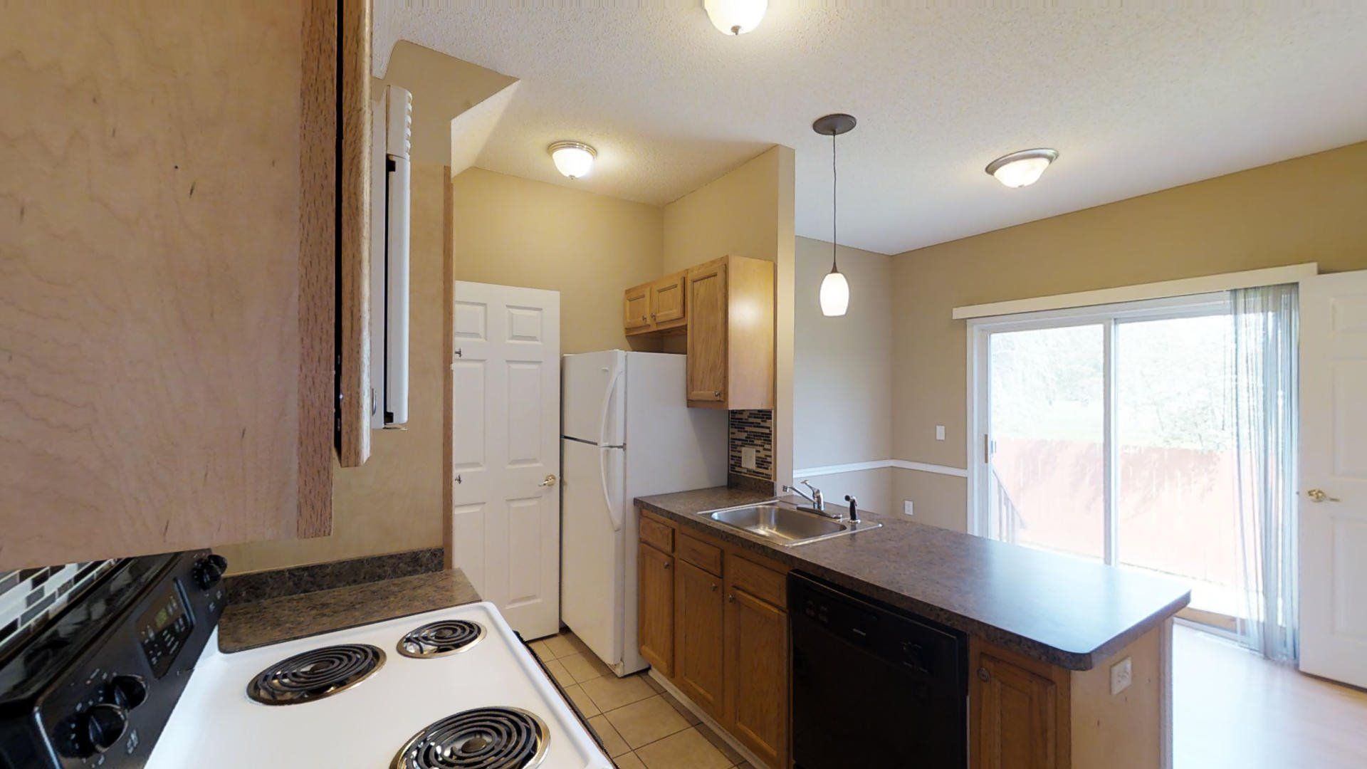 A kitchen with a stove , refrigerator , sink and dishwasher.