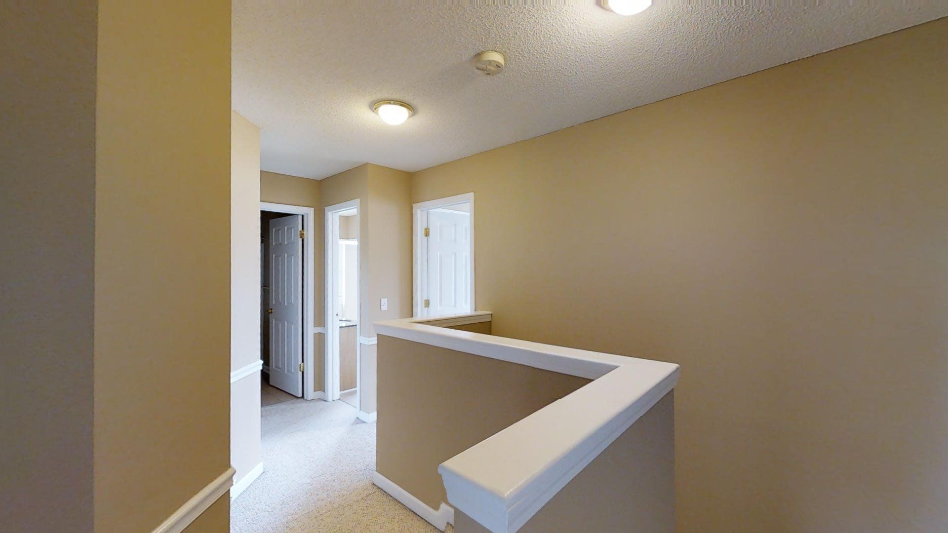 A hallway with stairs leading up to the second floor of a house.