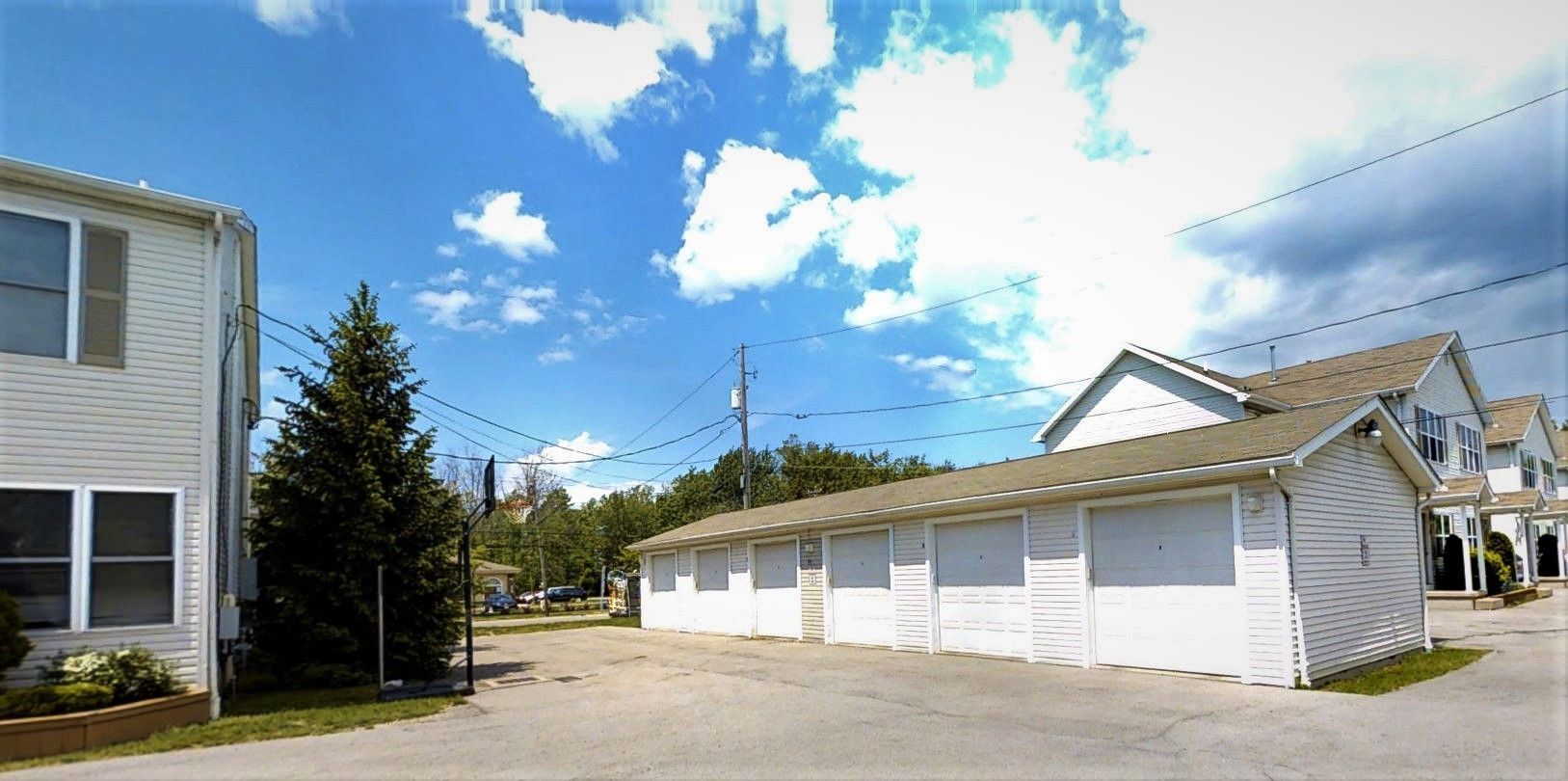 A row of white garages with a blue sky in the background