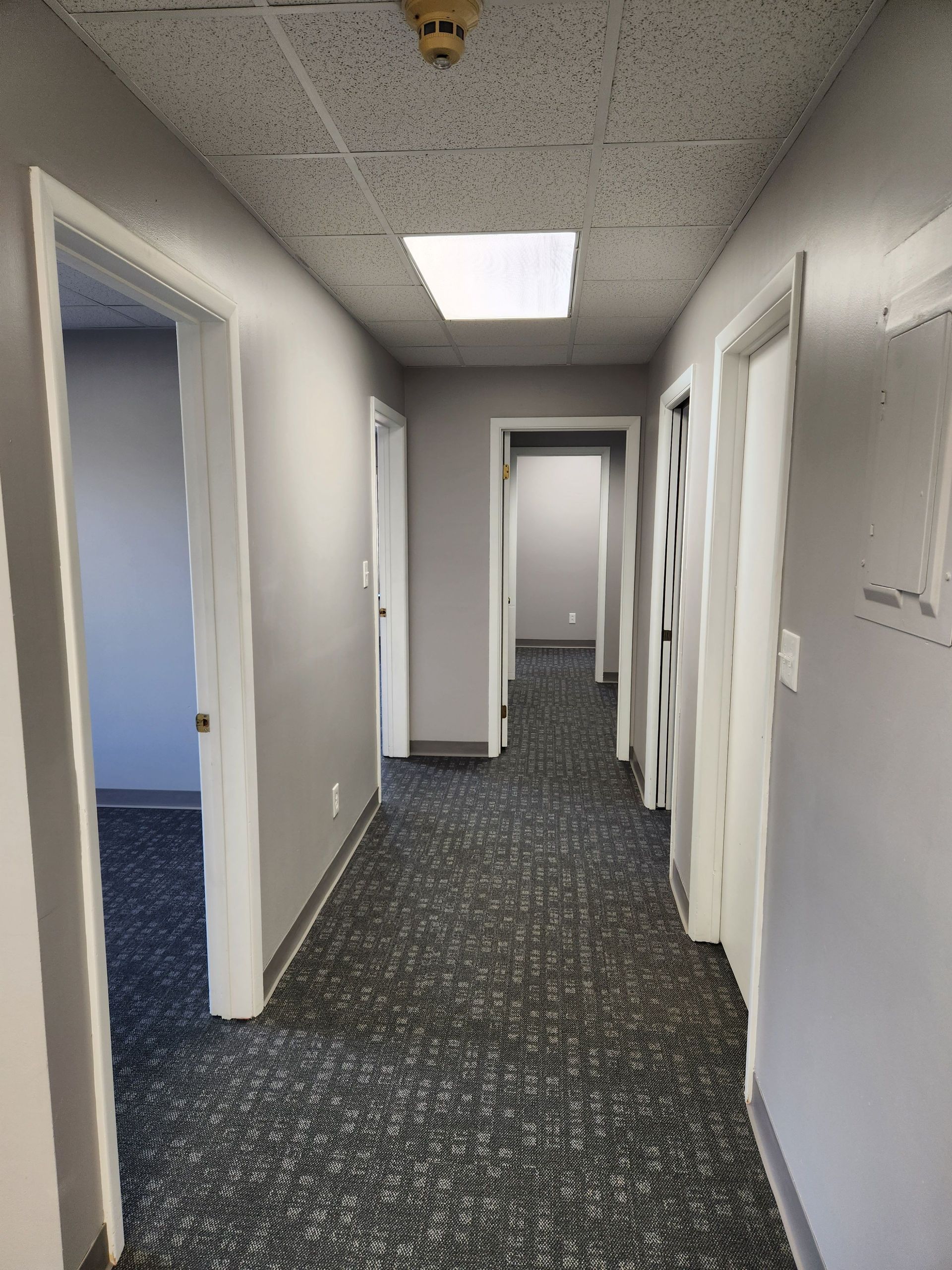A long hallway with a fire alarm on the ceiling