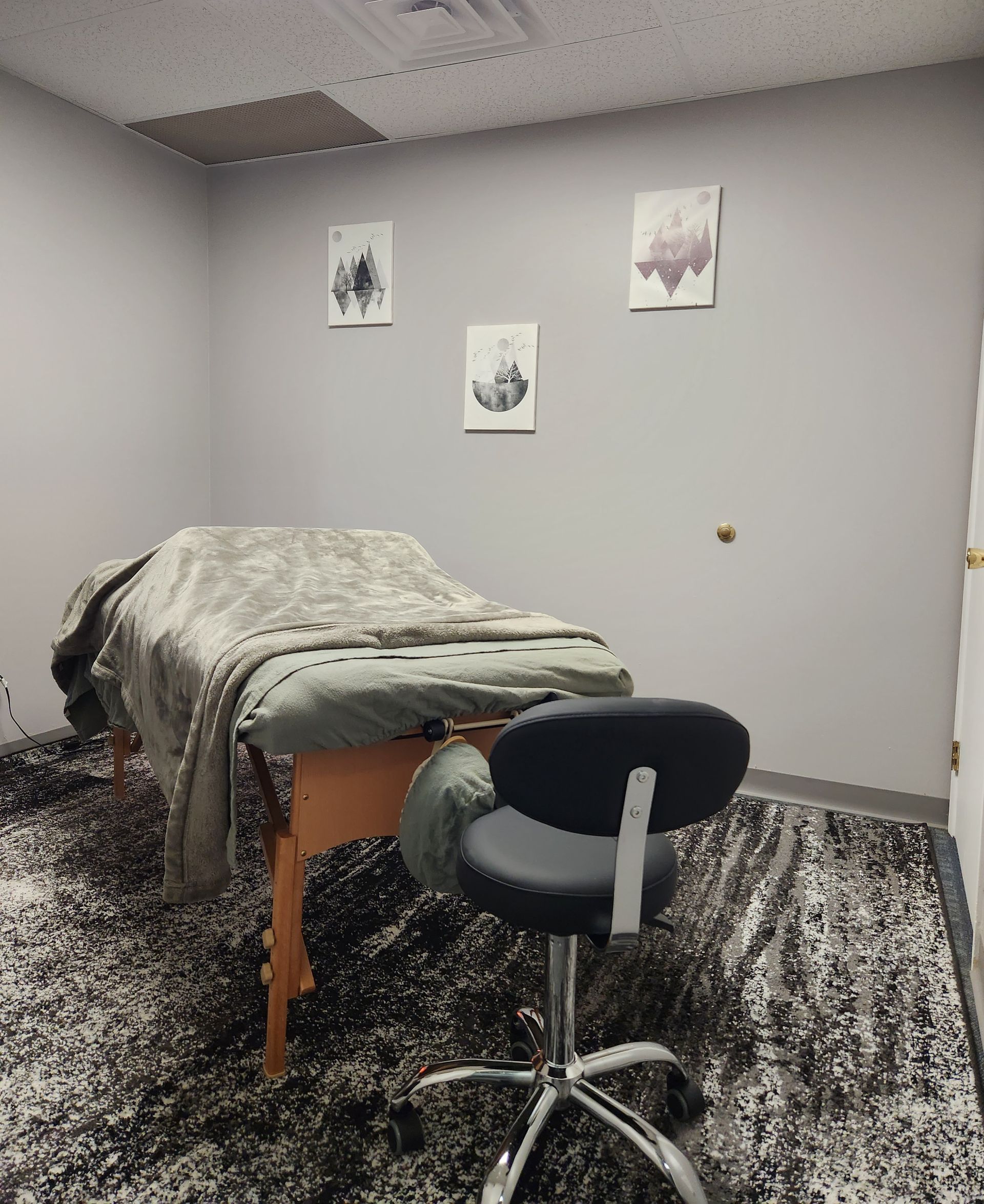 A massage table in a room with a chair