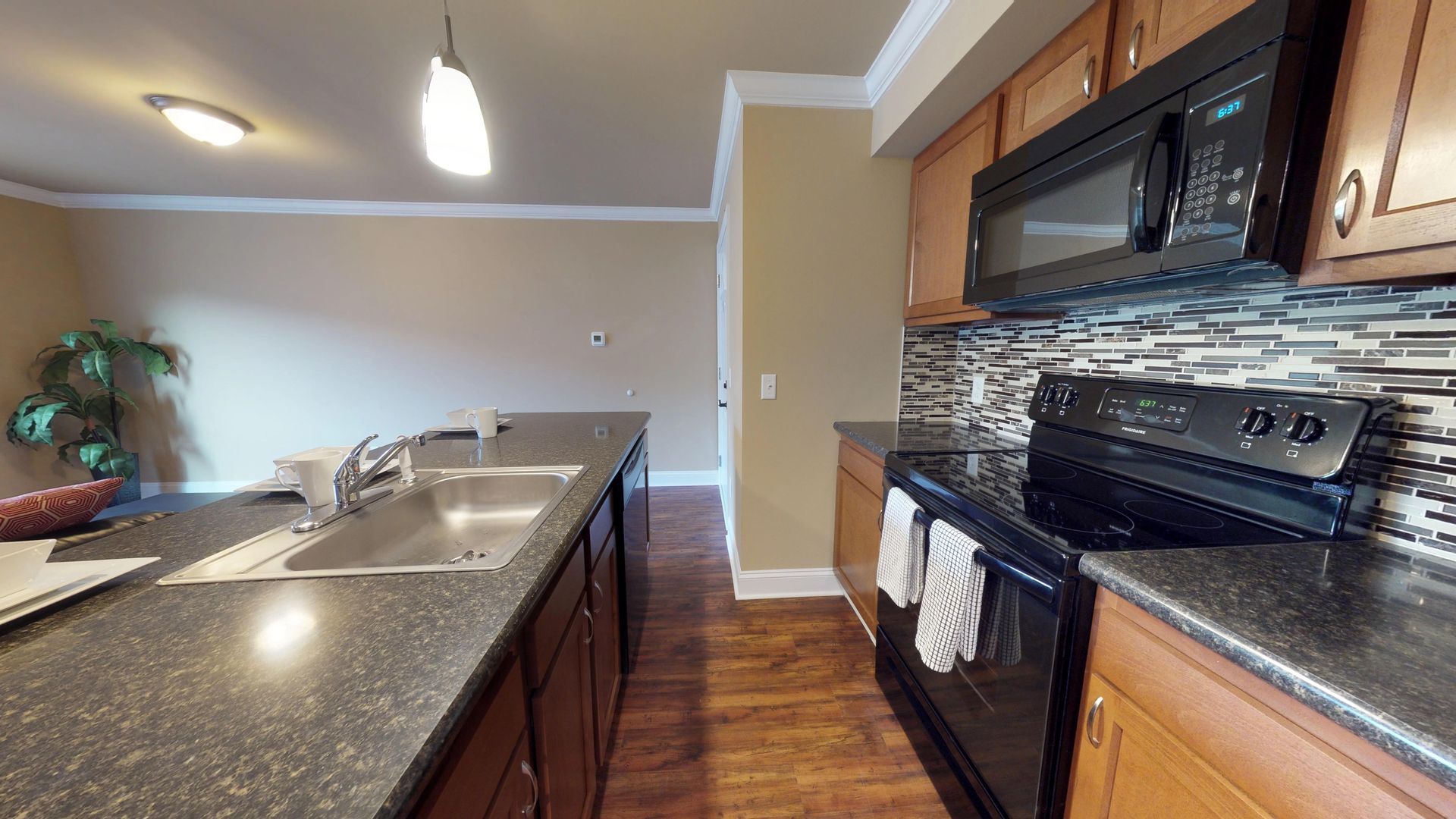 A kitchen with a sink , stove , and microwave.