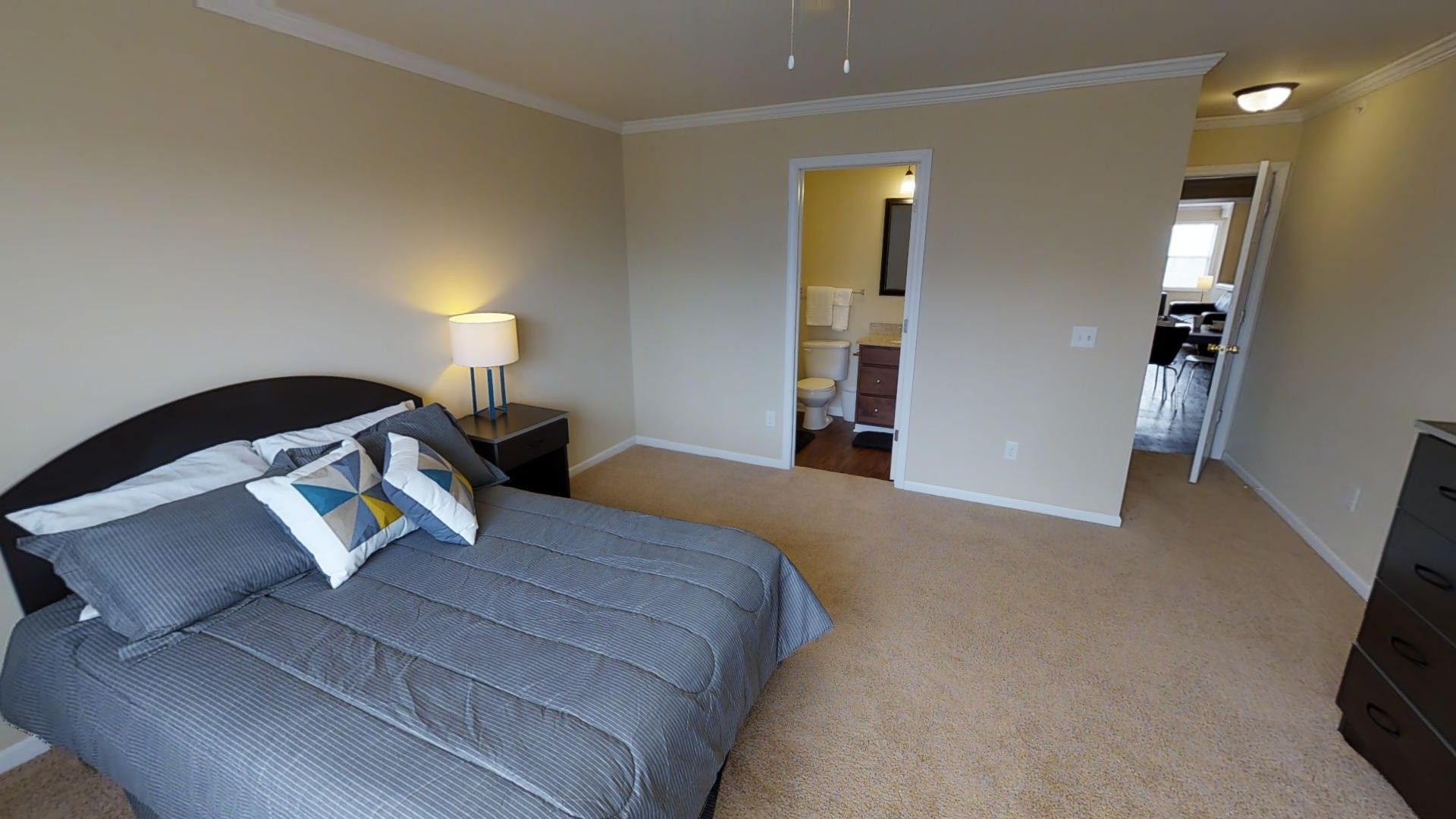 A bedroom with a large bed and a dresser.