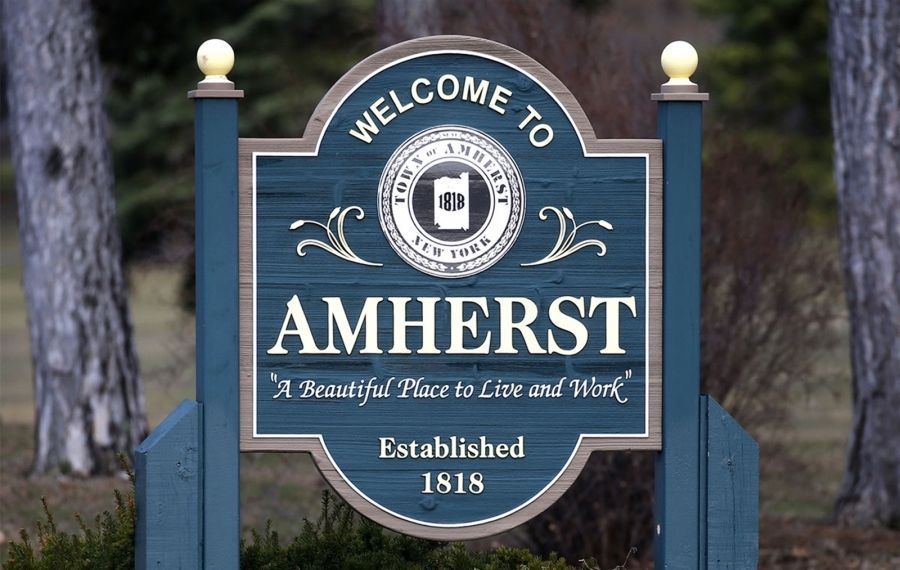 A blue sign that says welcome to amherst a beautiful place to live and work