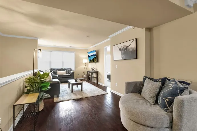 A living room with a couch , chair , table and television.