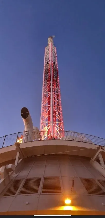 A very tall tower on top of a building with a blue sky in the background.