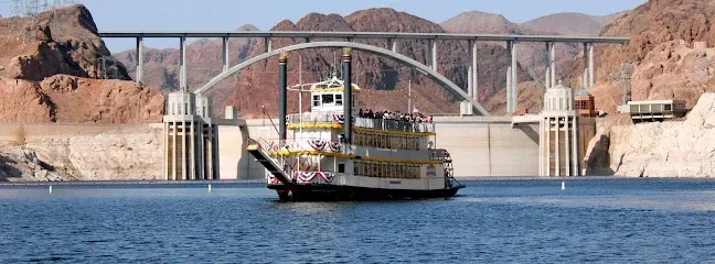 A boat is floating in the water under a bridge.