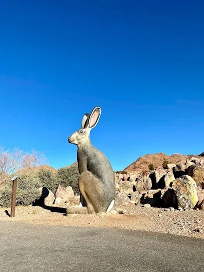 A statue of a rabbit is sitting on the side of a road.