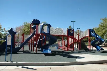 A playground with a blue slide and a red slide