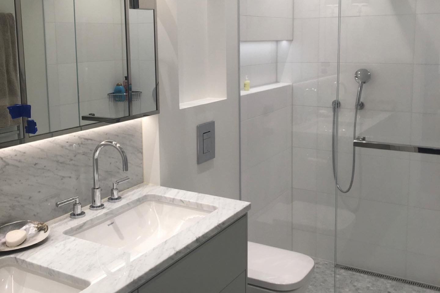 Klassisk moderne hvitt bad med marmorvask, glassdusj og grå detaljer.