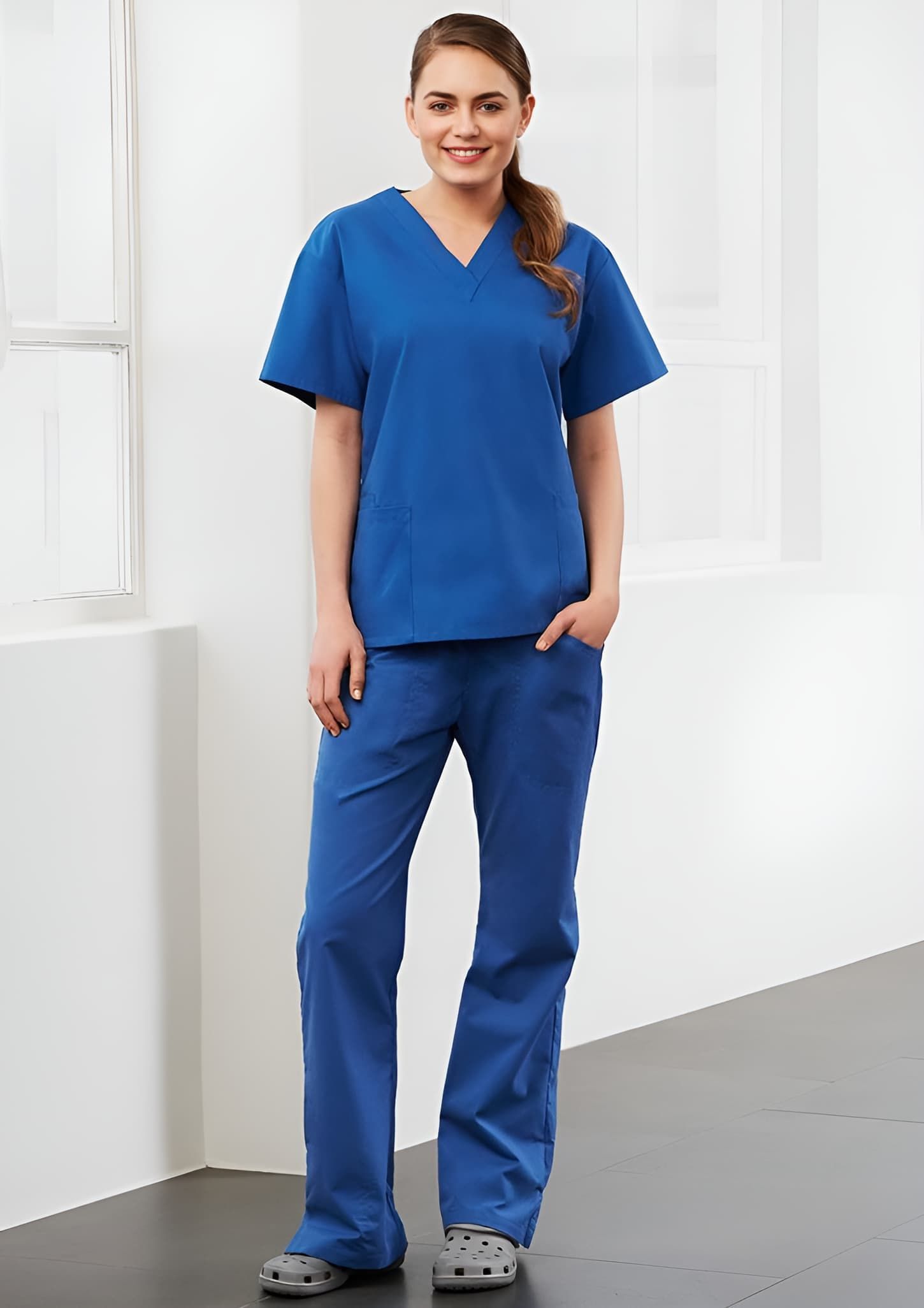 A Woman In A Blue Scrub Suit Is Standing In A Room — Caba's Drapery In Coffs Harbour, NSW