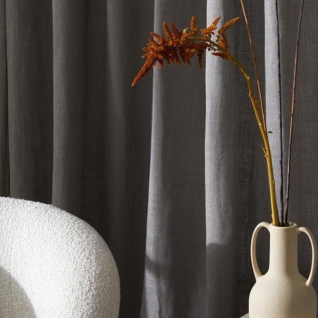 A Vase With A Flower In It Is Next To A Chair — Caba's Drapery In Coffs Harbour, NSW