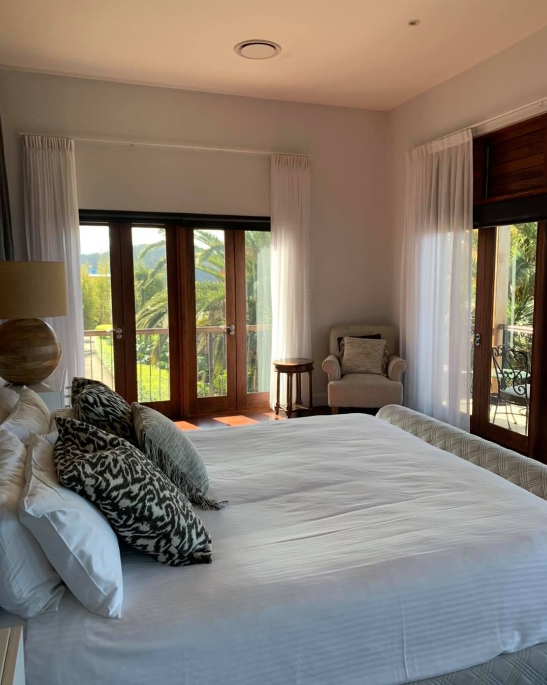 A Bedroom With A King Size Bed And A Chair — Caba's Drapery In Macksville, NSW