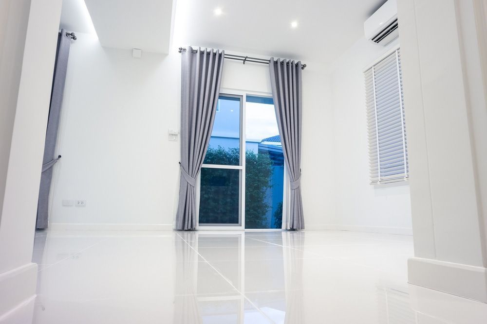 An Empty Living Room With A Sliding Glass Door And Curtains — Caba's Drapery In Coffs Harbour, NSW