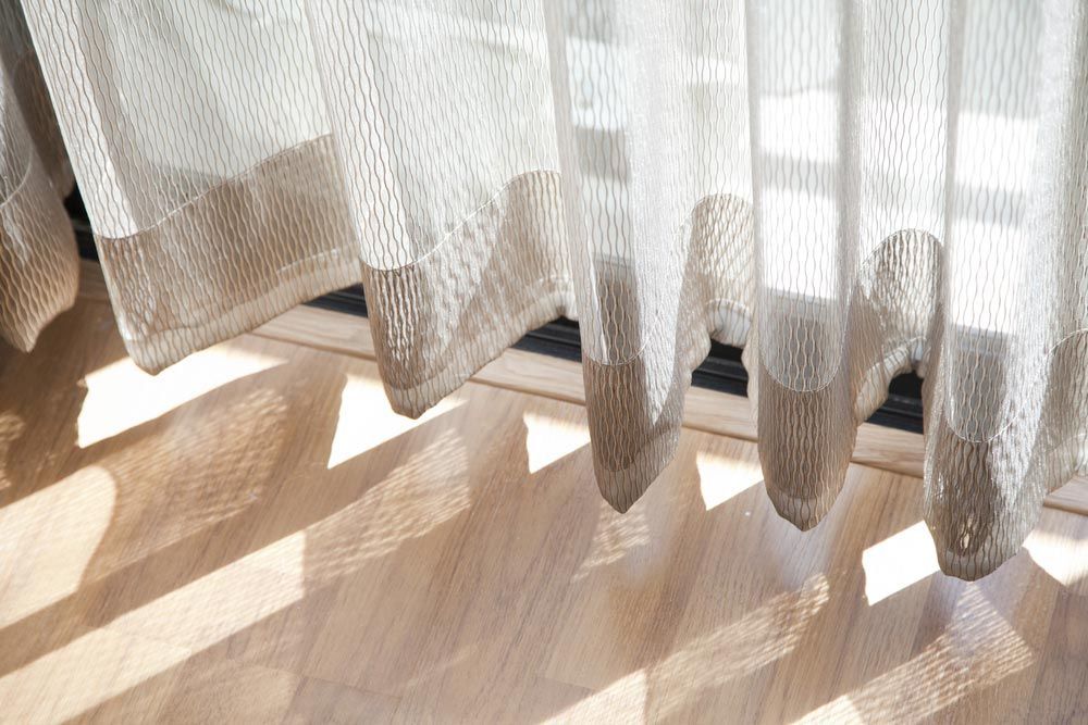A Close Up Of A White Curtain Hanging On A Window — Caba's Drapery In Coffs Harbour, NSW