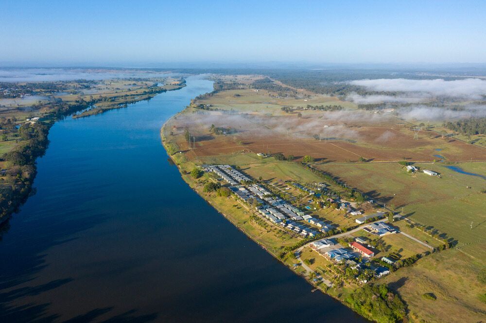 An Aerial View Of A River Surrounded By Fields And Houses — Caba's Drapery In Grafton, NSW