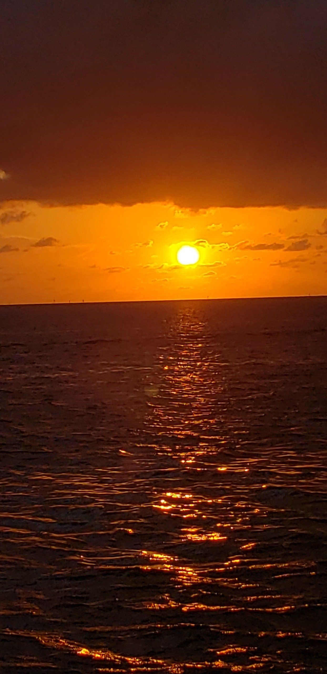 The sun is setting over the ocean.