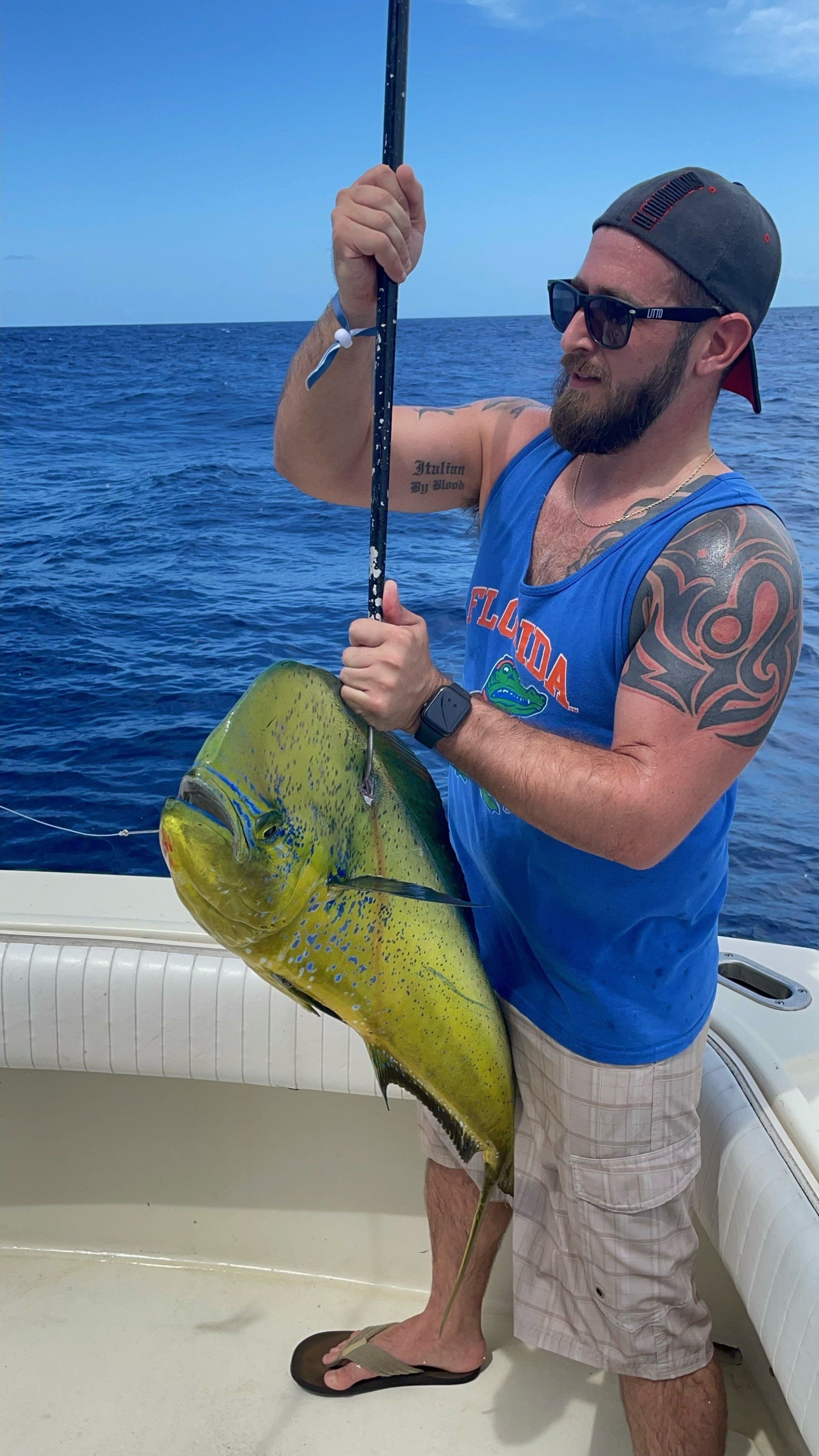 A man is holding a large fish on a boat.