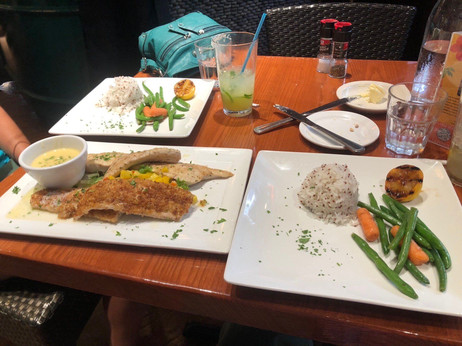 A wooden table topped with plates of food and drinks.