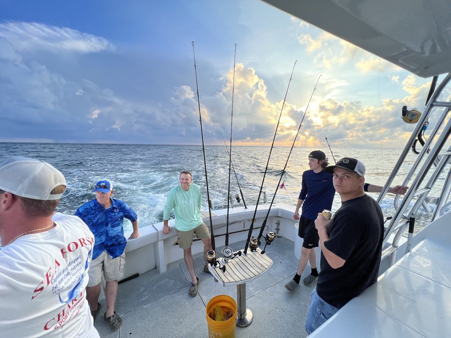 A group of men are fishing on a boat in the ocean.