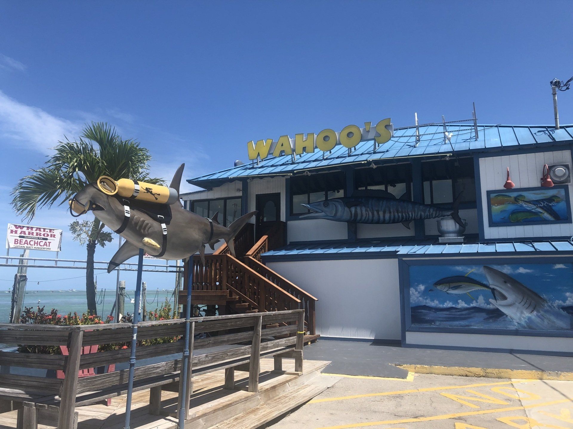 A restaurant with a shark statue in front of it.
