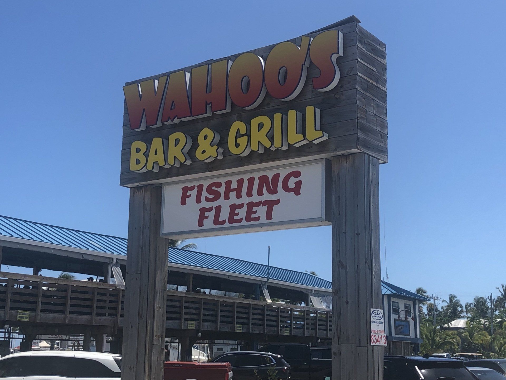 A sign for wahoo 's bar and grill fishing fleet