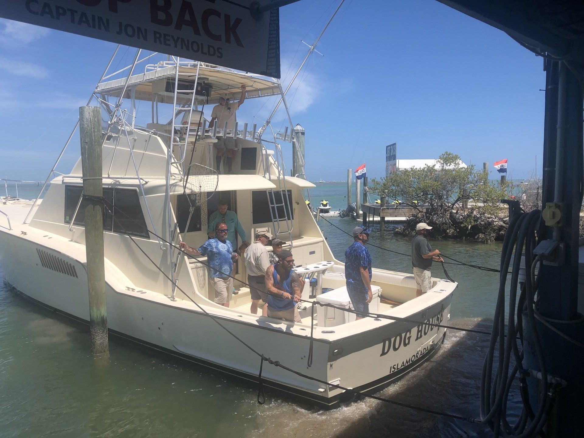 A group of people are standing on a boat in the water.