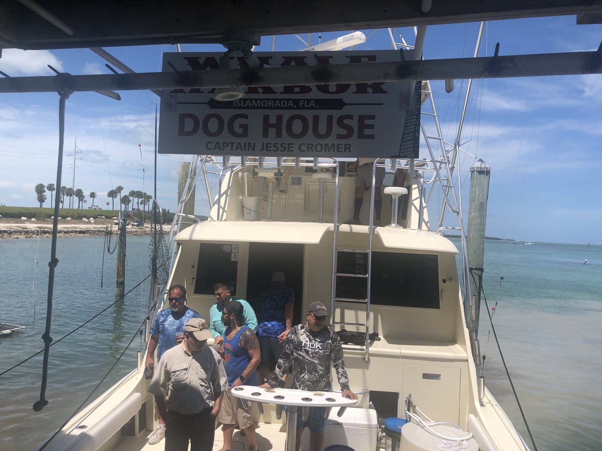A group of people standing on a boat that says dog house