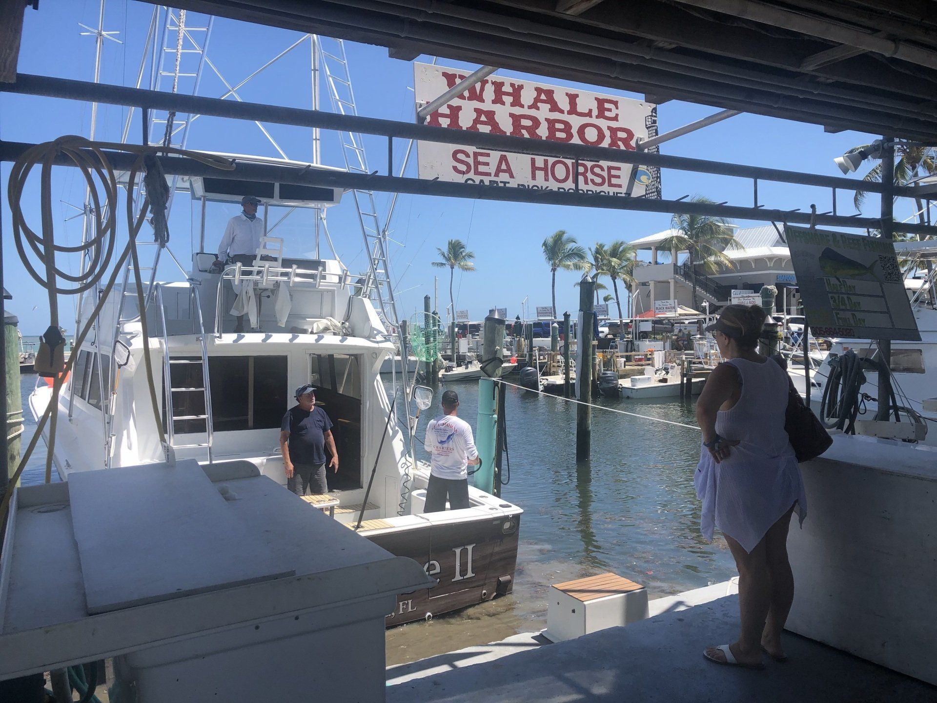 A sign for whale harbor sea house hangs above a boat