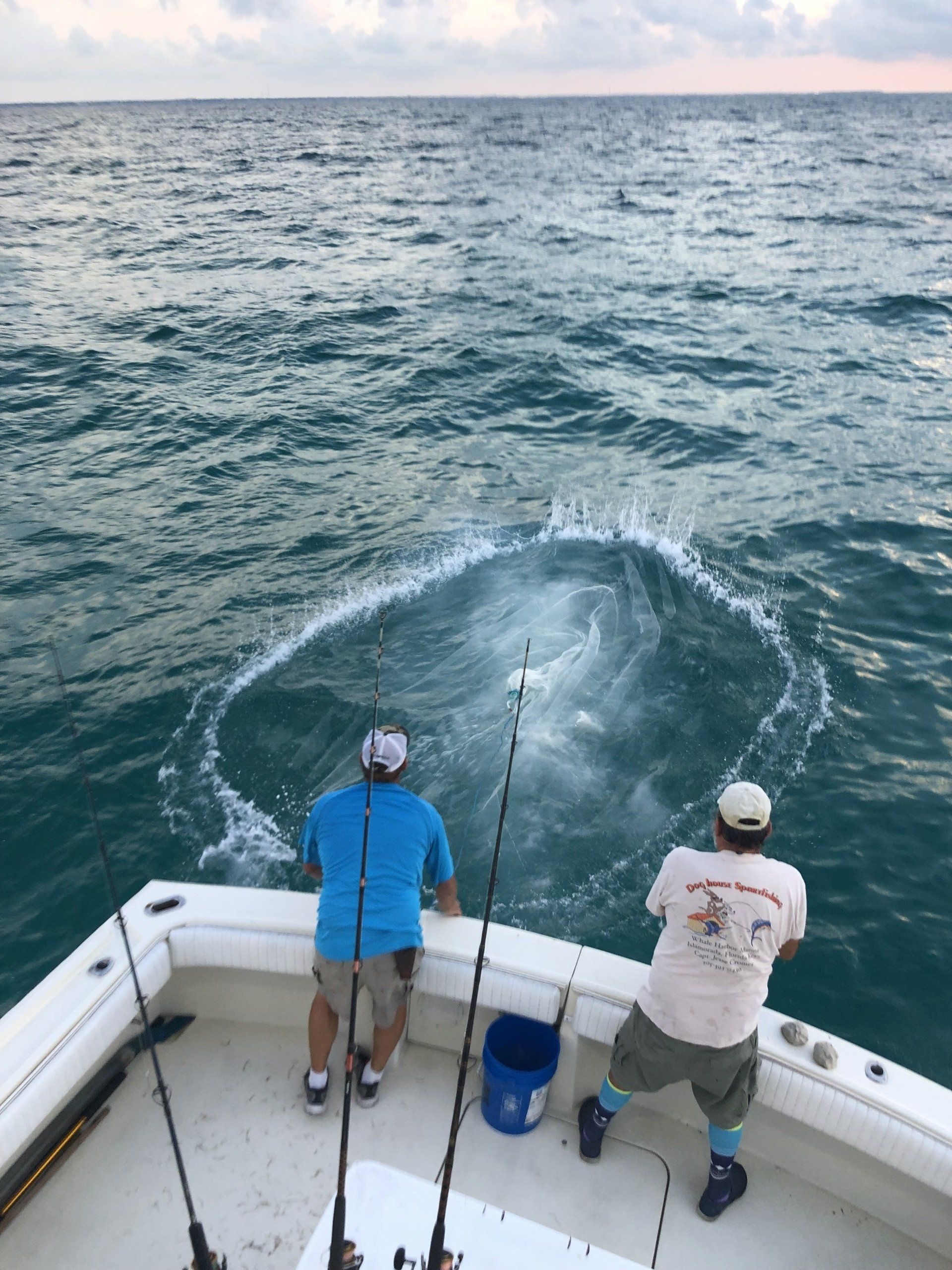 Two men are fishing on a boat in the ocean