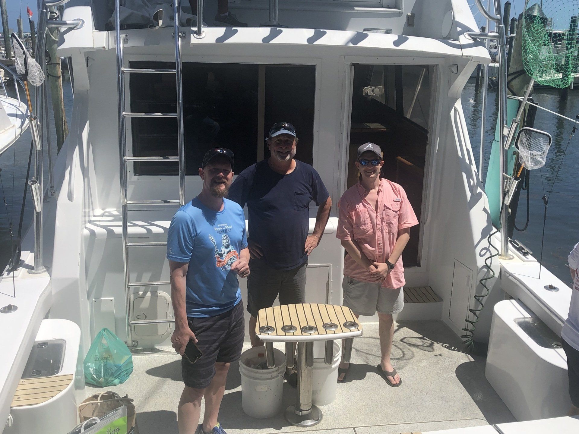 Three men are standing on the deck of a boat