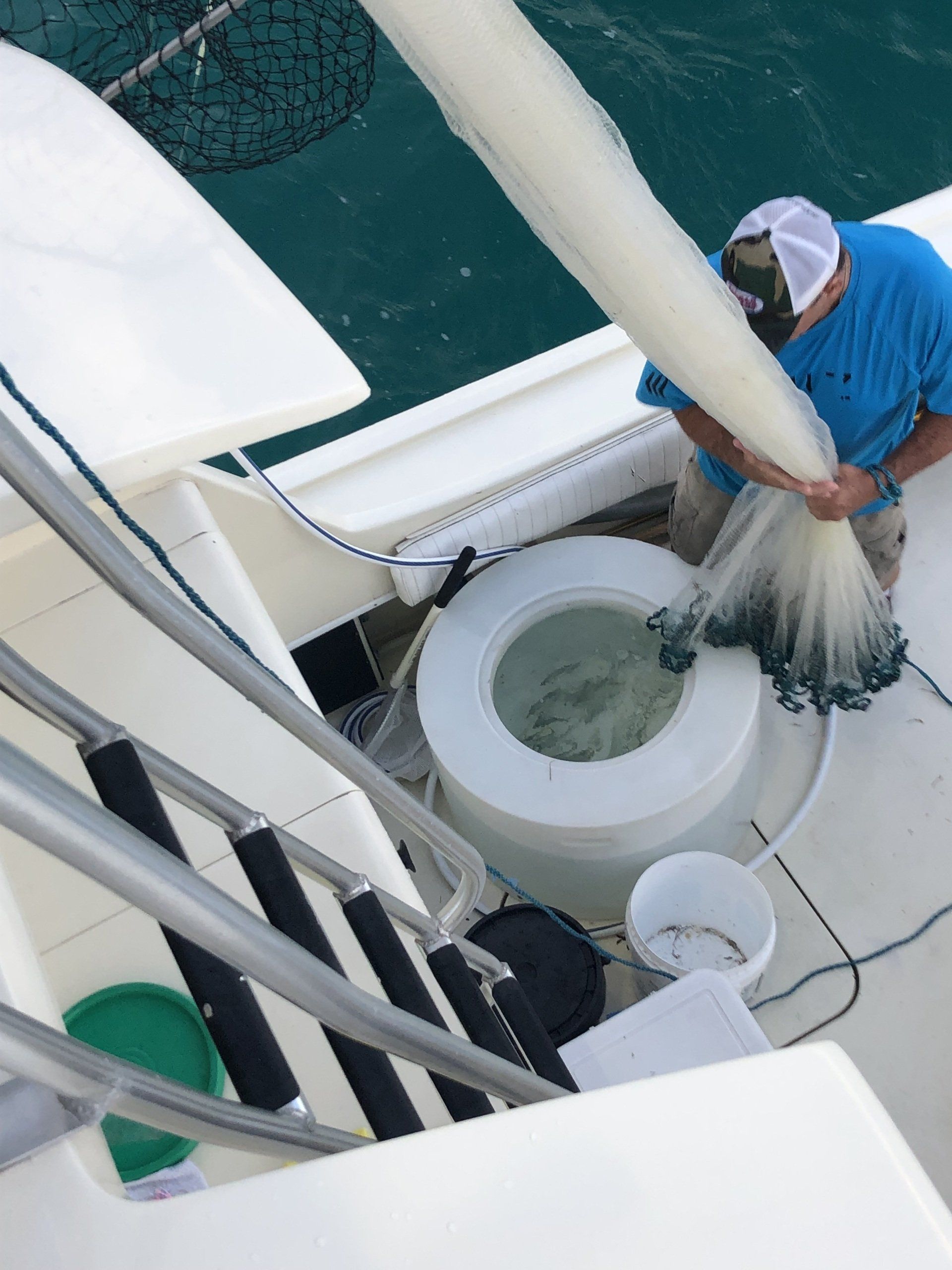 A man in a blue shirt is fishing on a boat