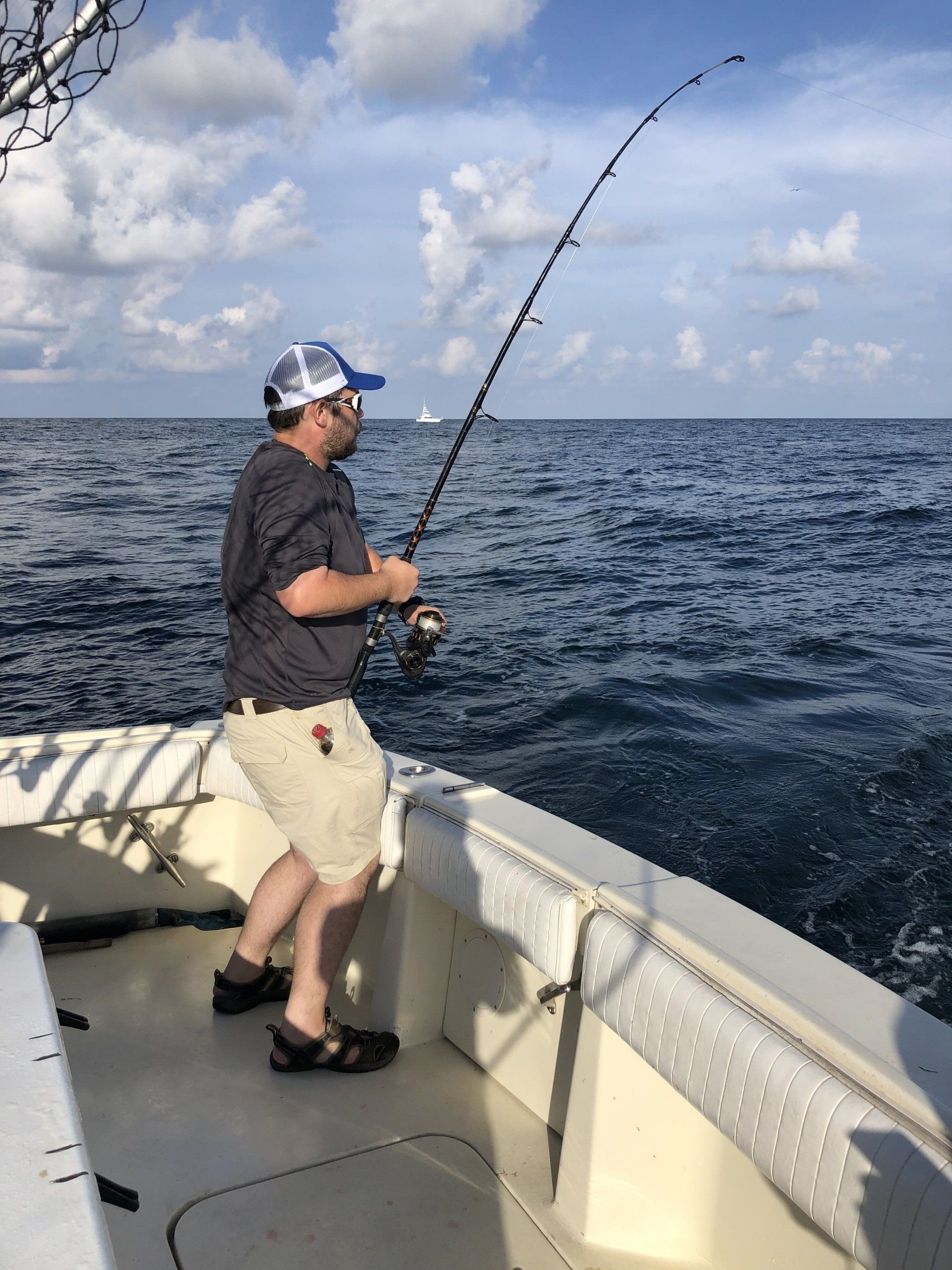 A man is fishing on a boat in the ocean