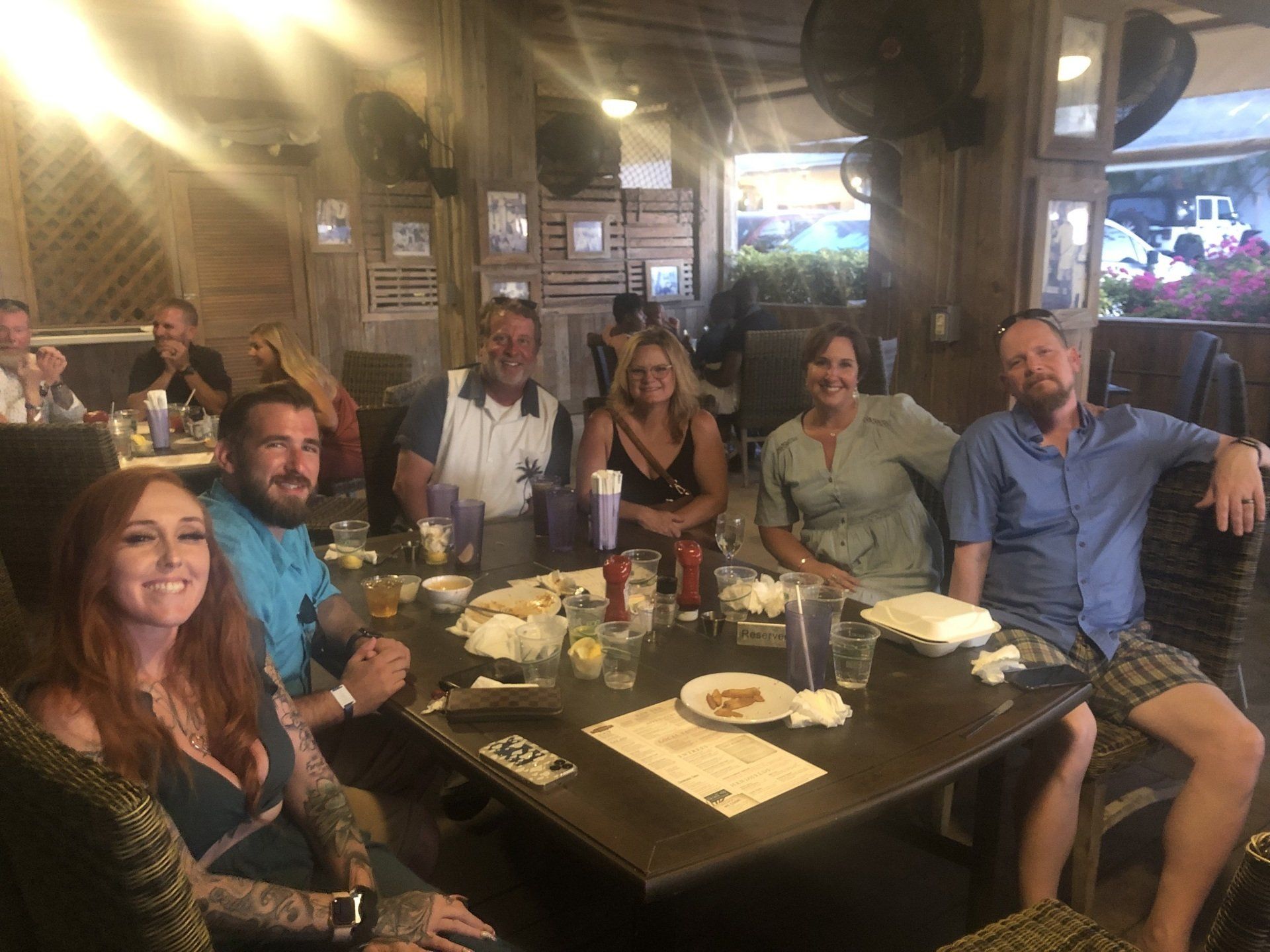 A group of people are sitting around a table in a restaurant.